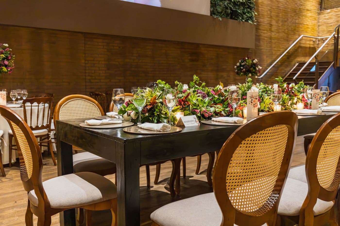 Dark wood table set with greenery centerpiece