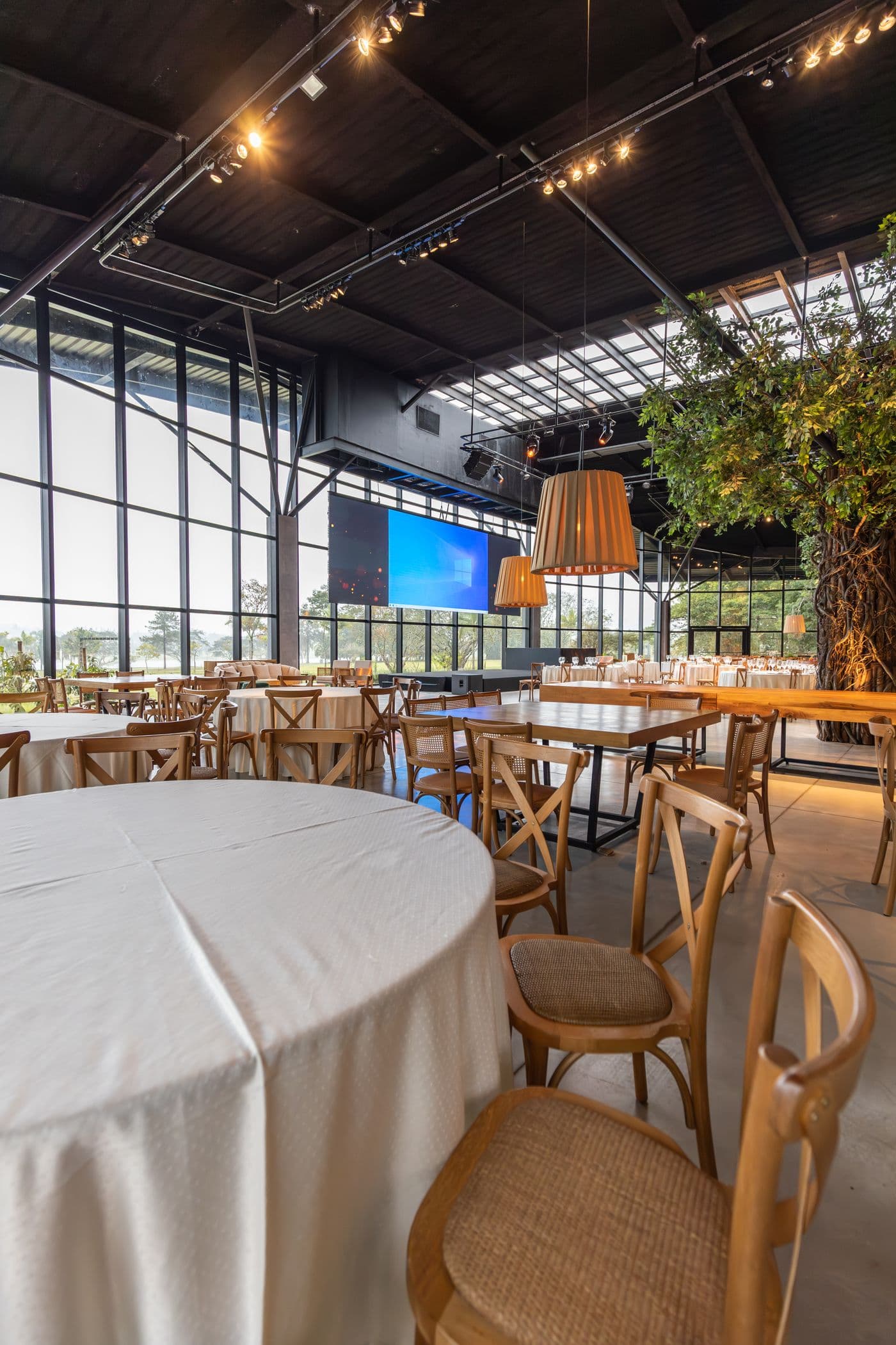 Airy loft venue with round tables and string lights