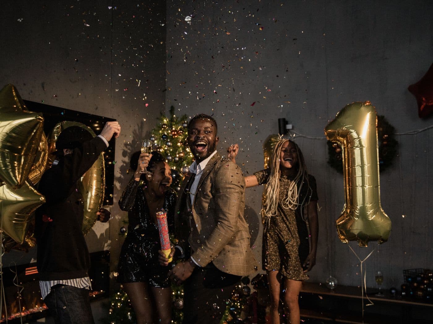Friends celebrating with confetti and gold balloons
